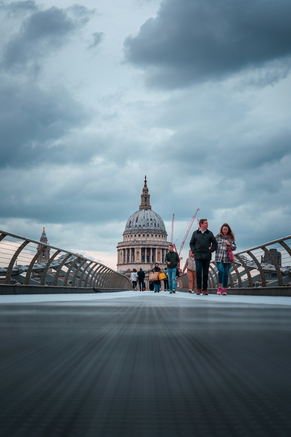 a group of people walking across a bridge