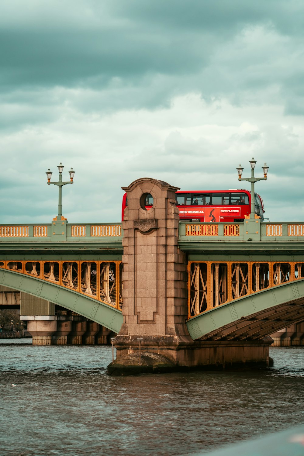 a red double decker bus crossing a bridge