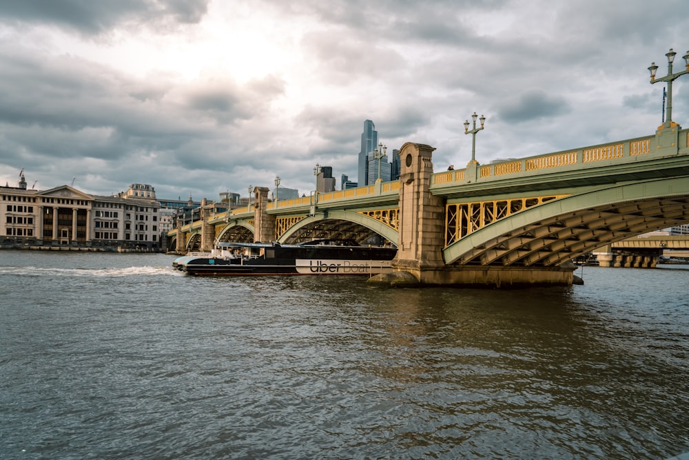 a boat traveling down a river under a bridge