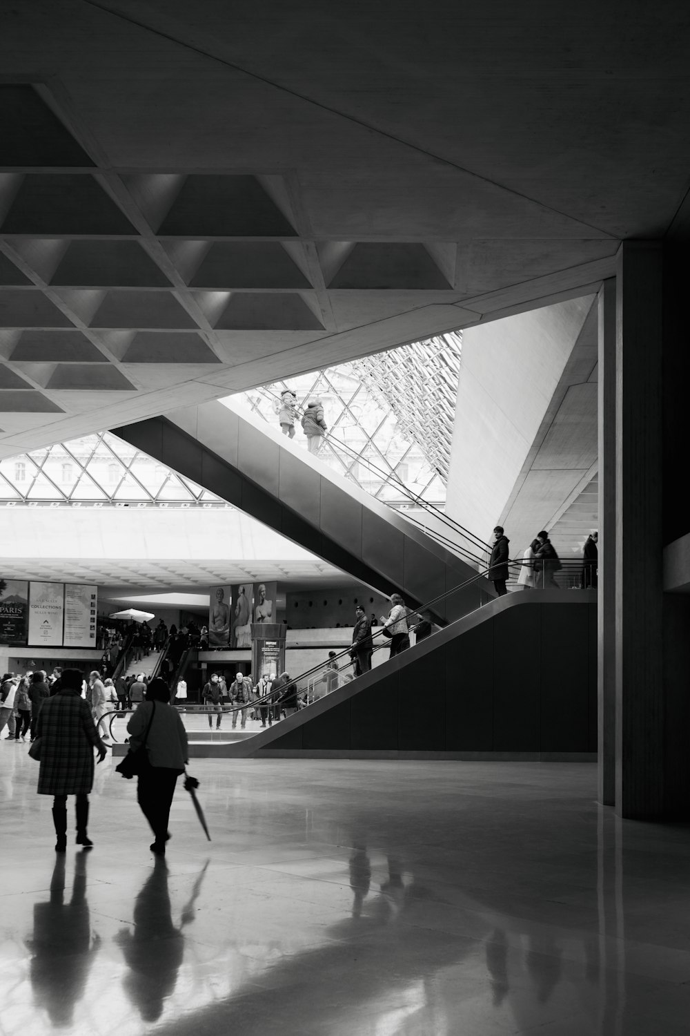 a black and white photo of people walking in a building
