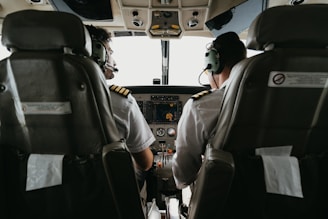 two pilots sitting in the cockpit of a plane