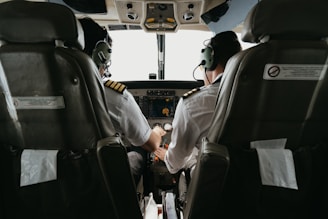 two pilots sitting in the cockpit of a plane