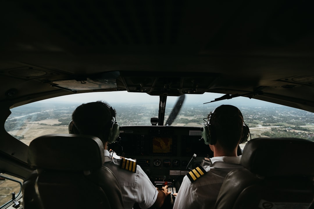 a couple of pilots sitting in the cockpit of a plane, airplane cabin with pilot