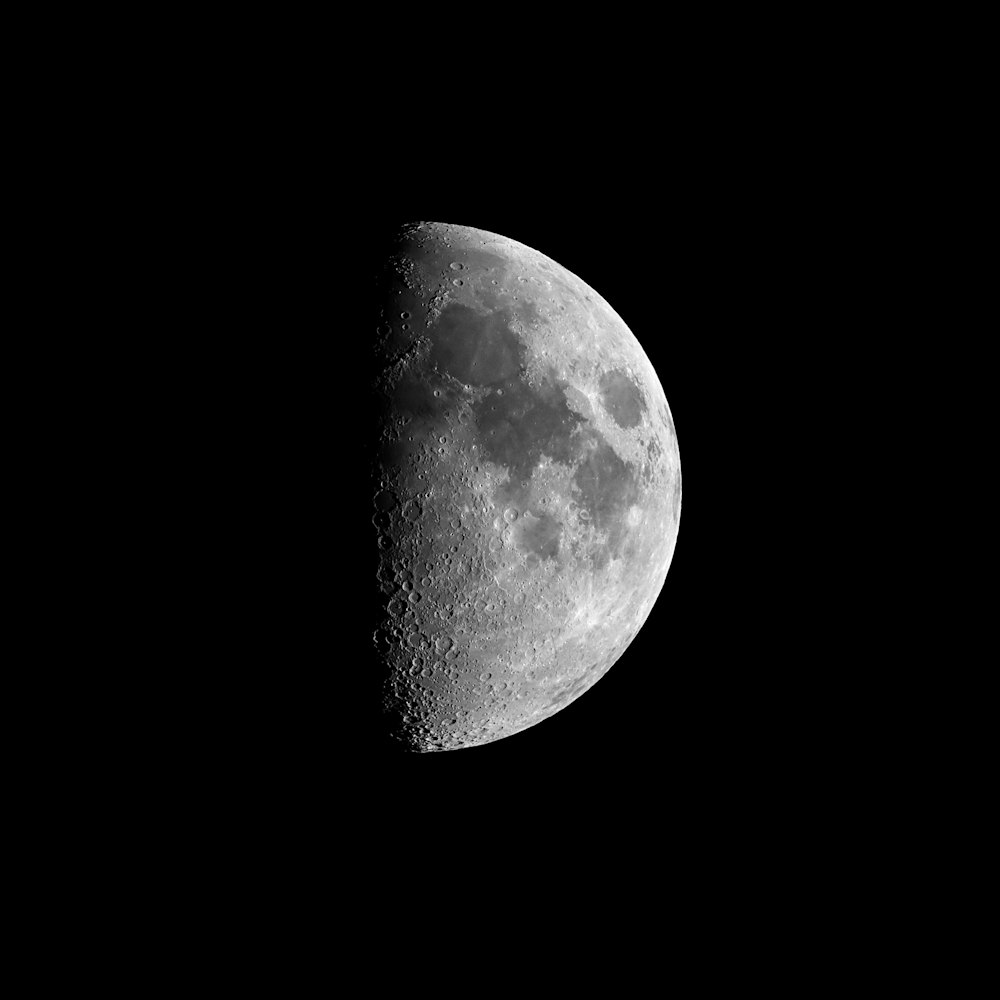 a half moon is seen in the dark sky