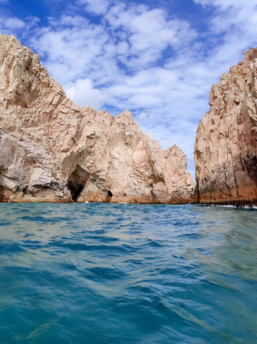 a body of water with rocks in the background