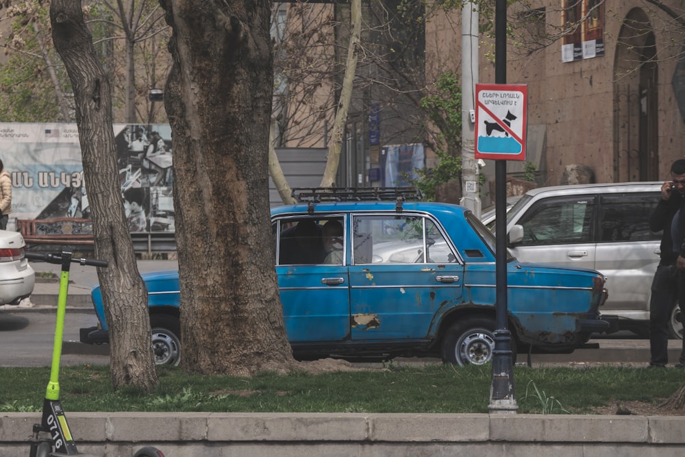 ein blaues Auto, das am Straßenrand geparkt ist