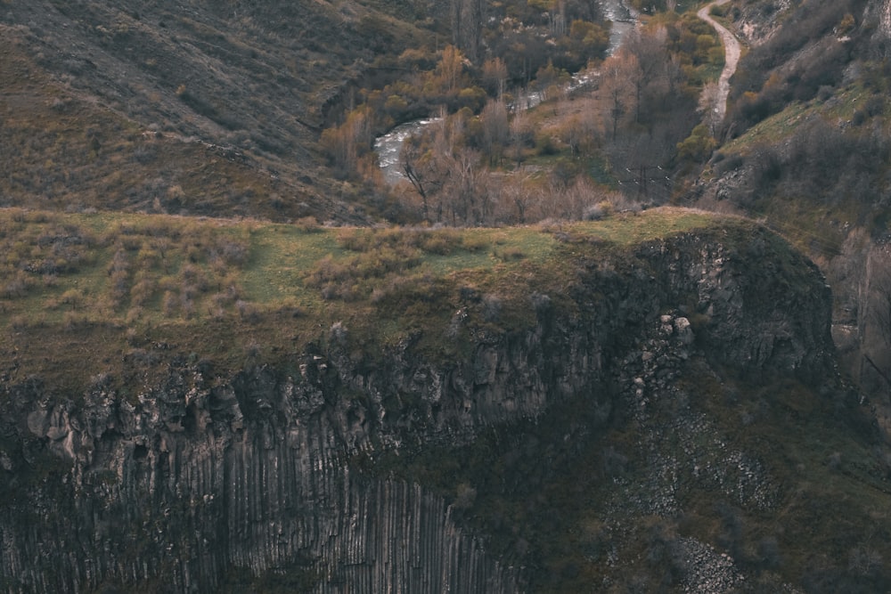 a mountain side with a river running through it