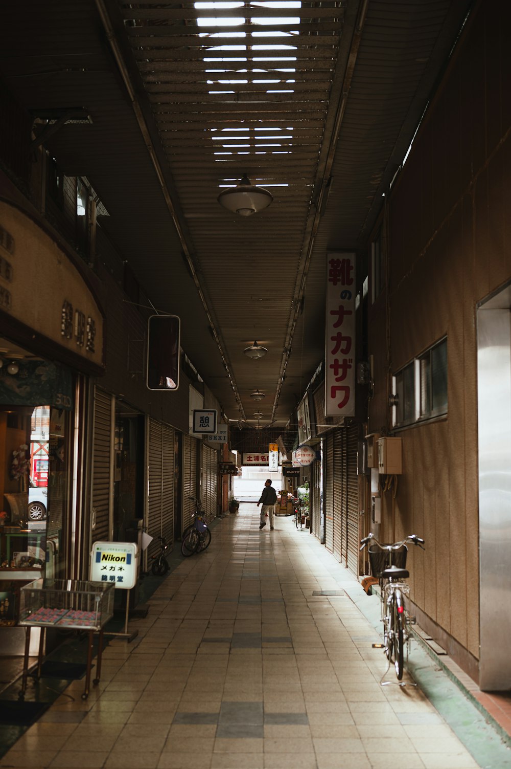 a person walking down a long hallway between two buildings