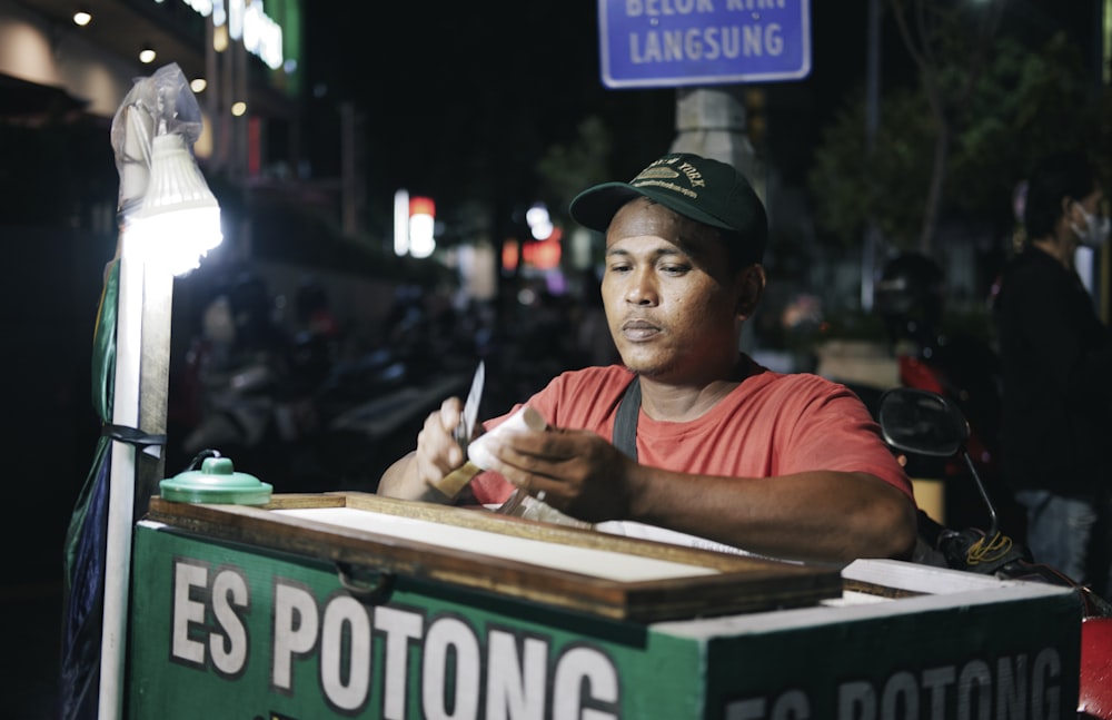 a man sitting at a table writing on a piece of paper