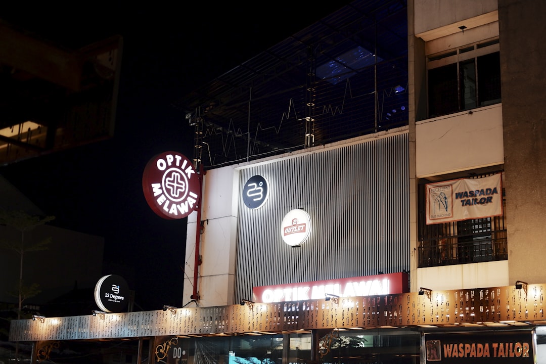 a building that has a sign on the side of it, Photo of the building at night