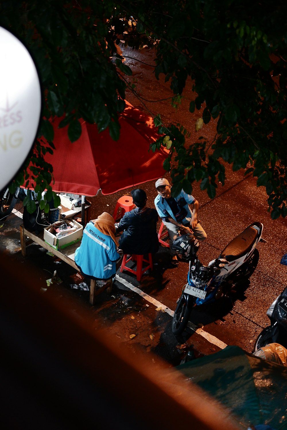a group of people sitting at a table under umbrellas