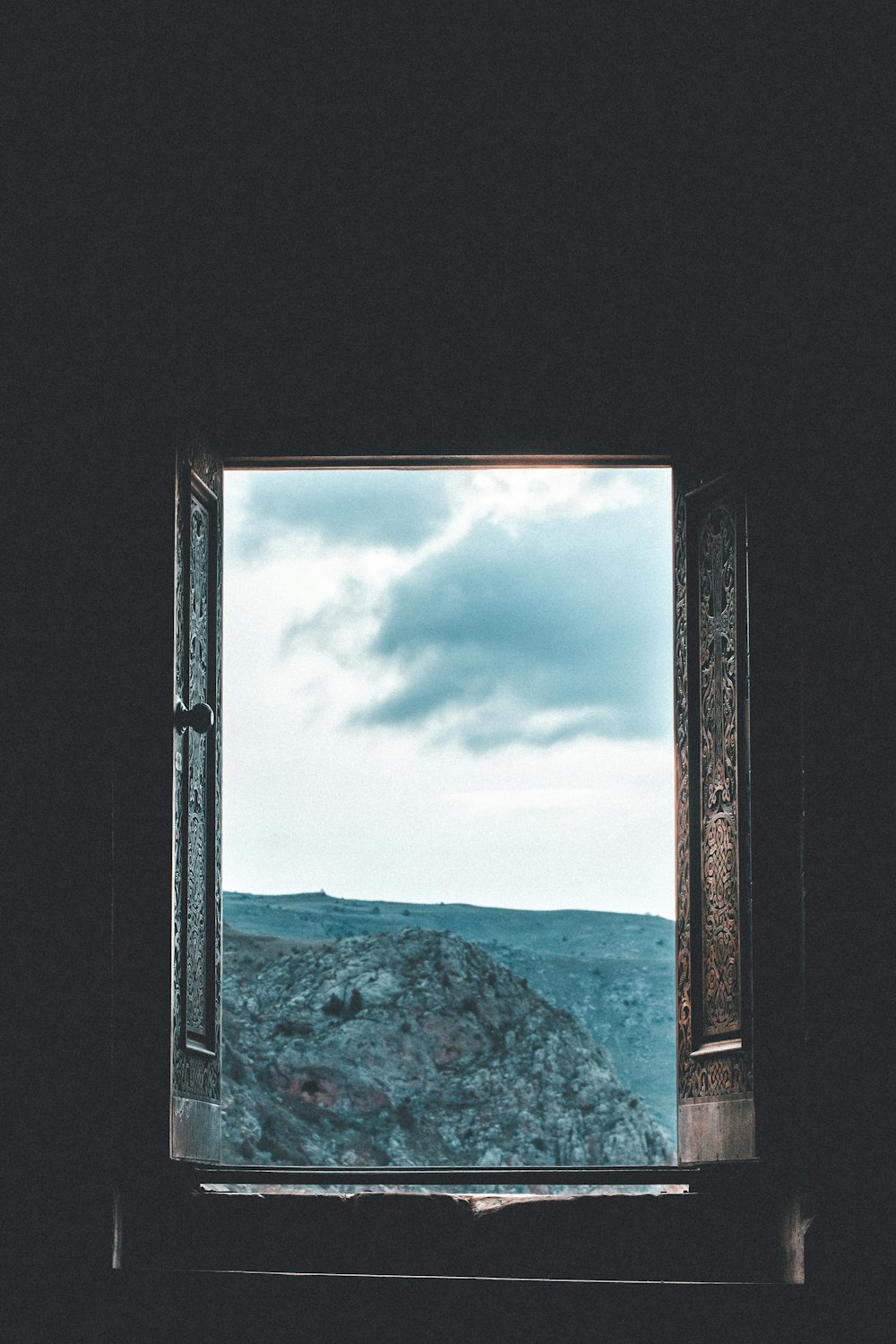 an open window with a view of a mountain