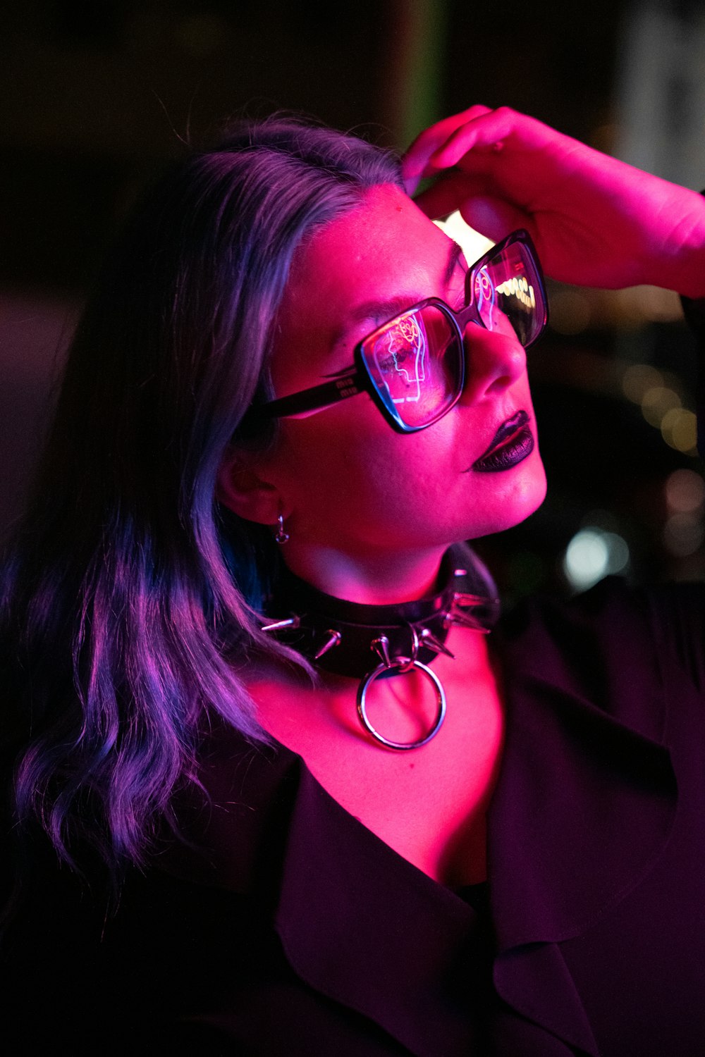 a woman wearing glasses and a choker