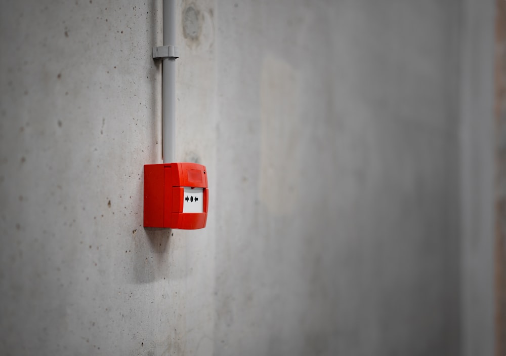 a red light switch on a concrete wall