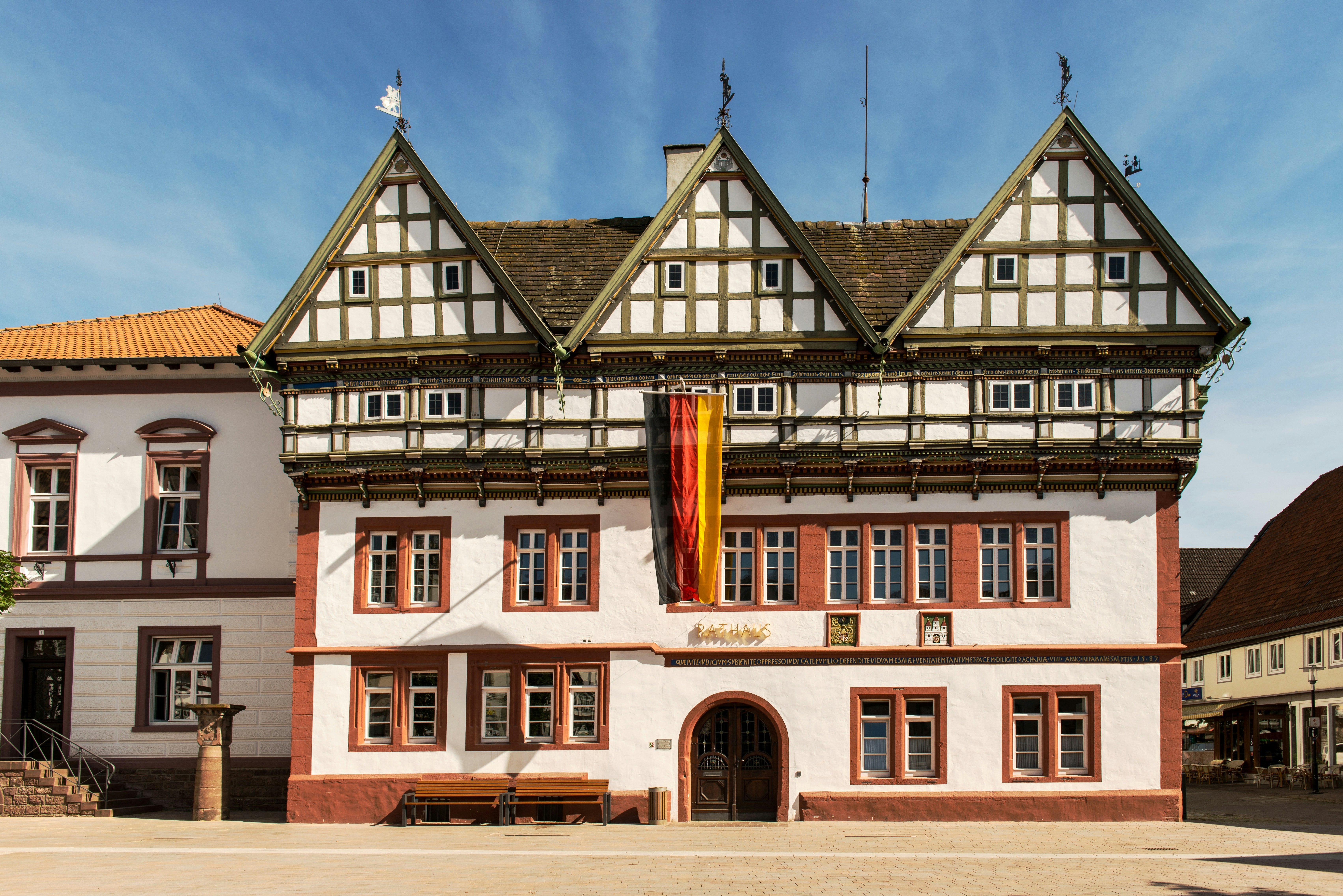 a large white and brown building with a flag on top of it