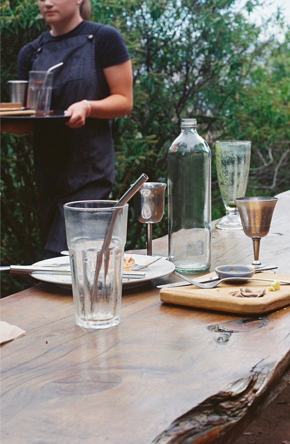 a woman standing at a table with a tray of food