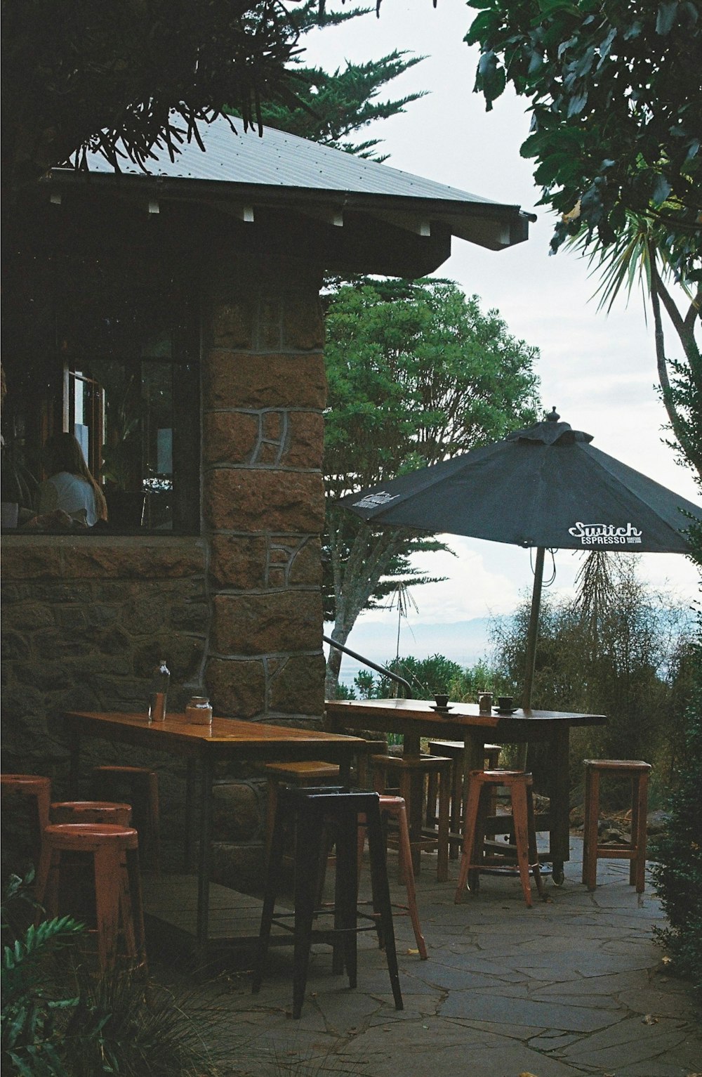 a patio with tables and umbrellas on a cloudy day