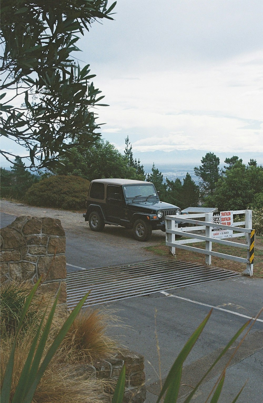 a jeep is parked in front of a white fence