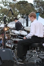 a man sitting on a chair in front of a drum set