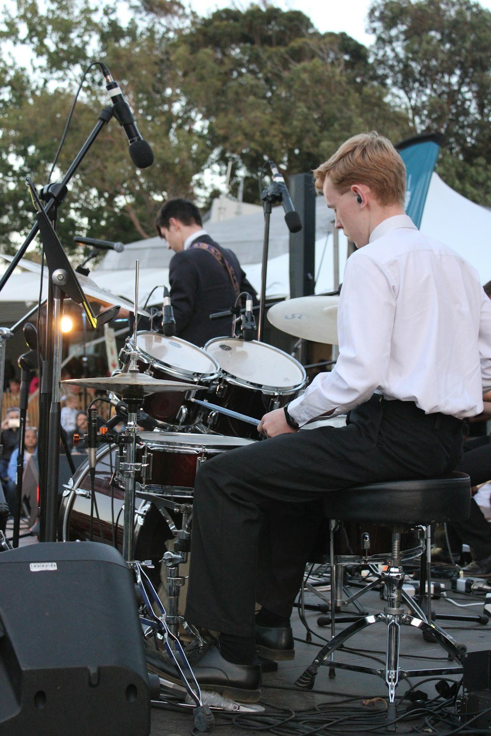 a man sitting on a chair in front of a drum set