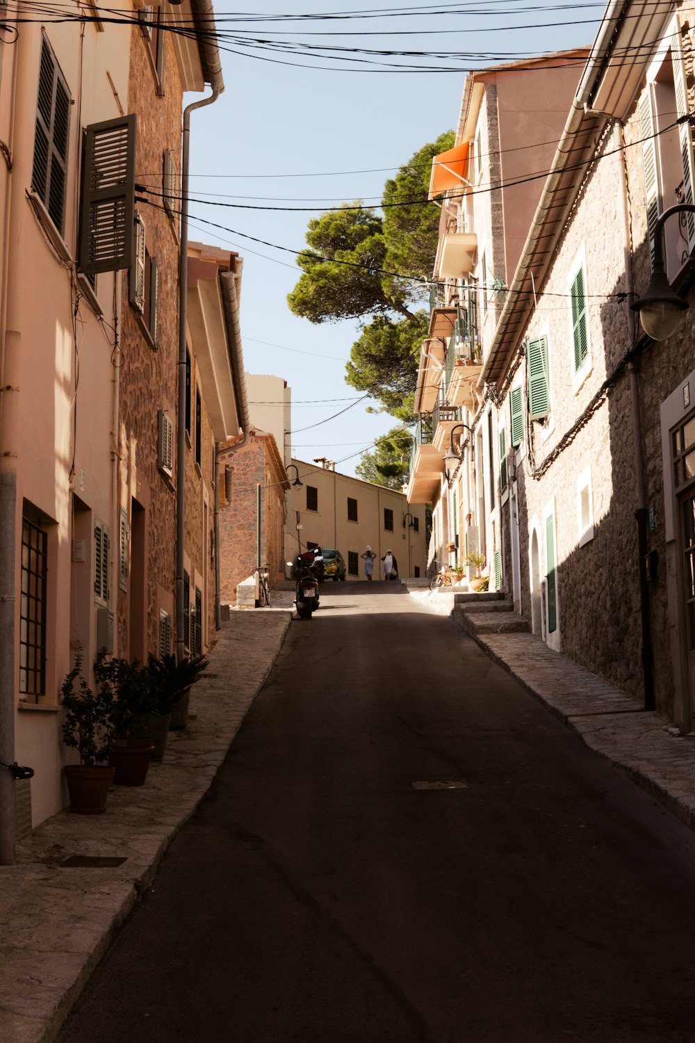 a motorcycle is parked on the side of a narrow street