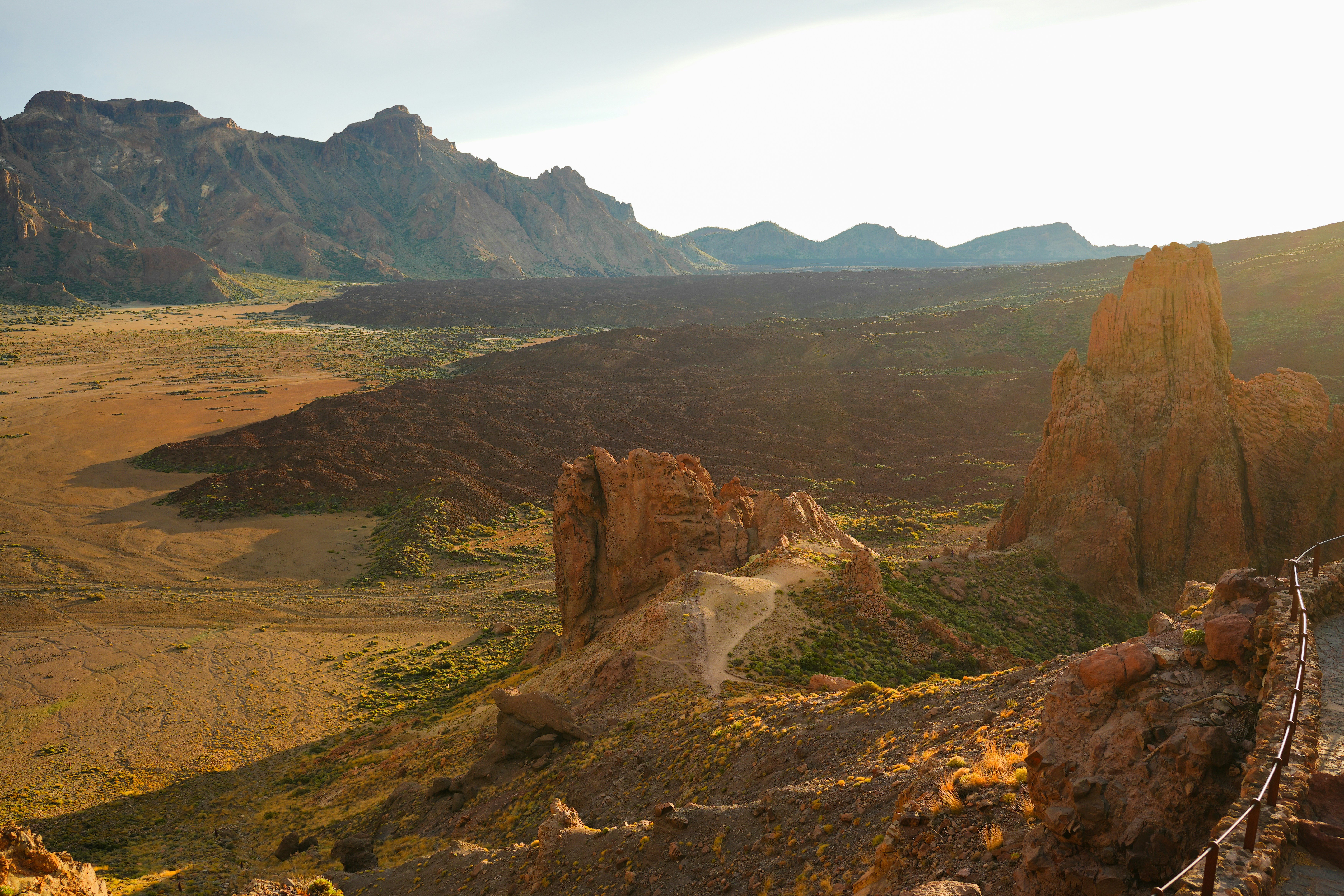 a scenic view of a mountain range with a bridge in the foreground