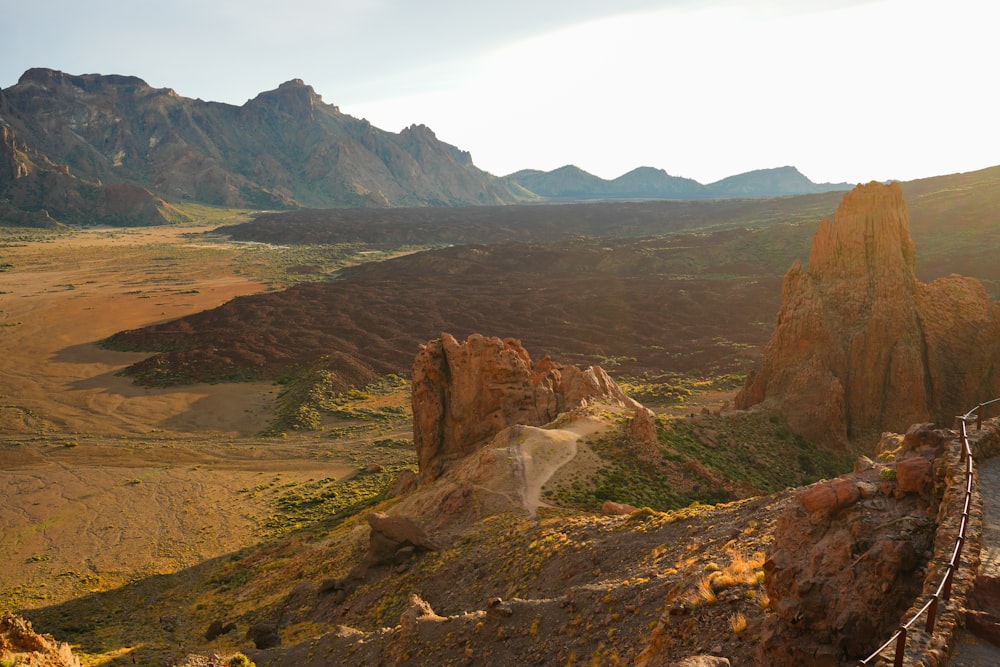 a scenic view of a mountain range with a bridge in the foreground