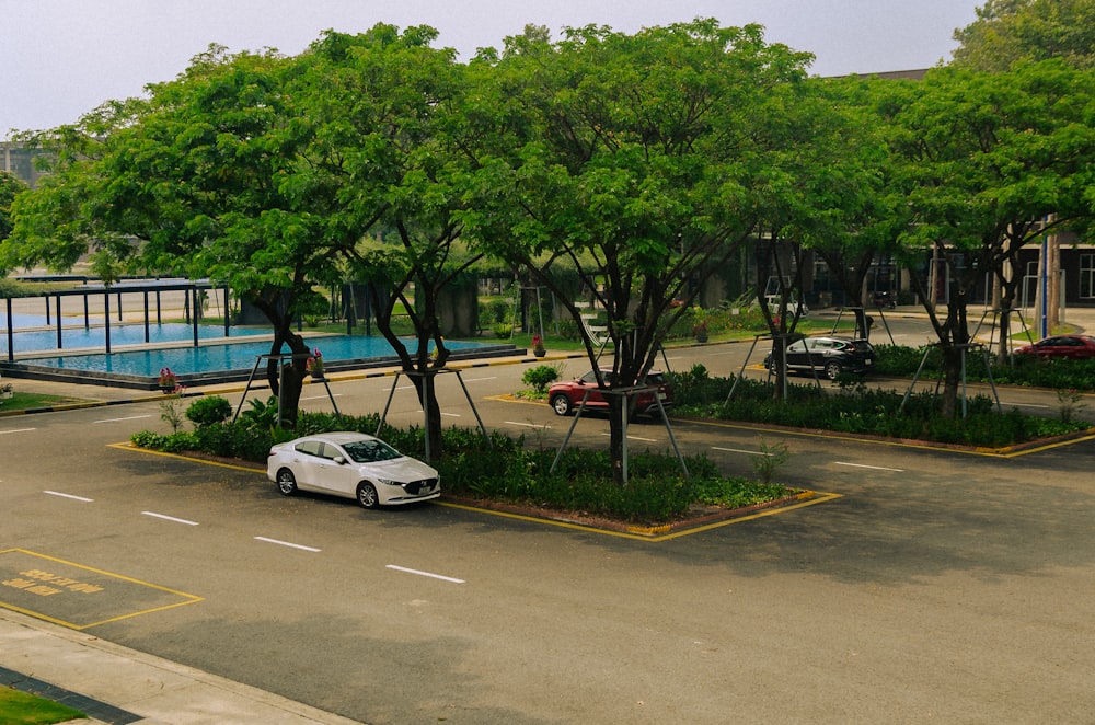 a white car parked in a parking lot next to a swimming pool