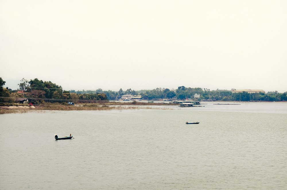 um par de barcos flutuando no topo de um lago