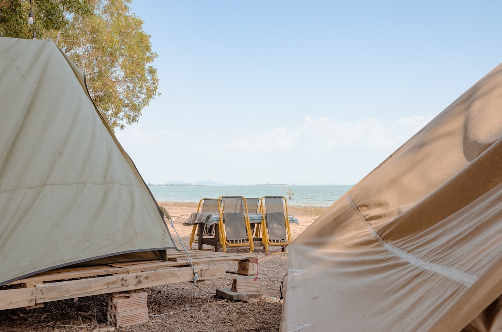 a couple of tents sitting on top of a sandy beach