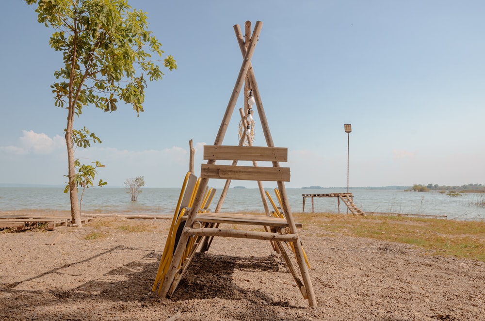 a wooden ladder sitting on top of a sandy beach