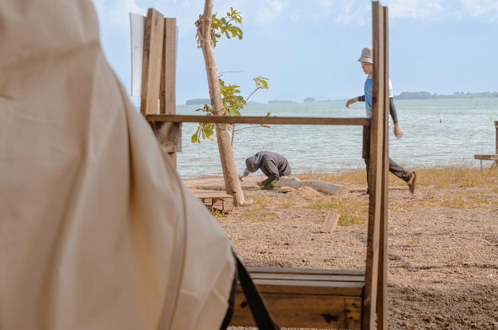 a man standing on a beach next to a body of water