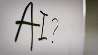 The letters AI and a question mark written in black marker on a whiteboard