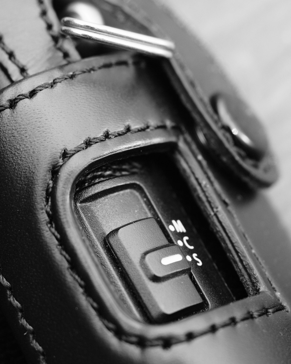 a close up of a button on a leather case