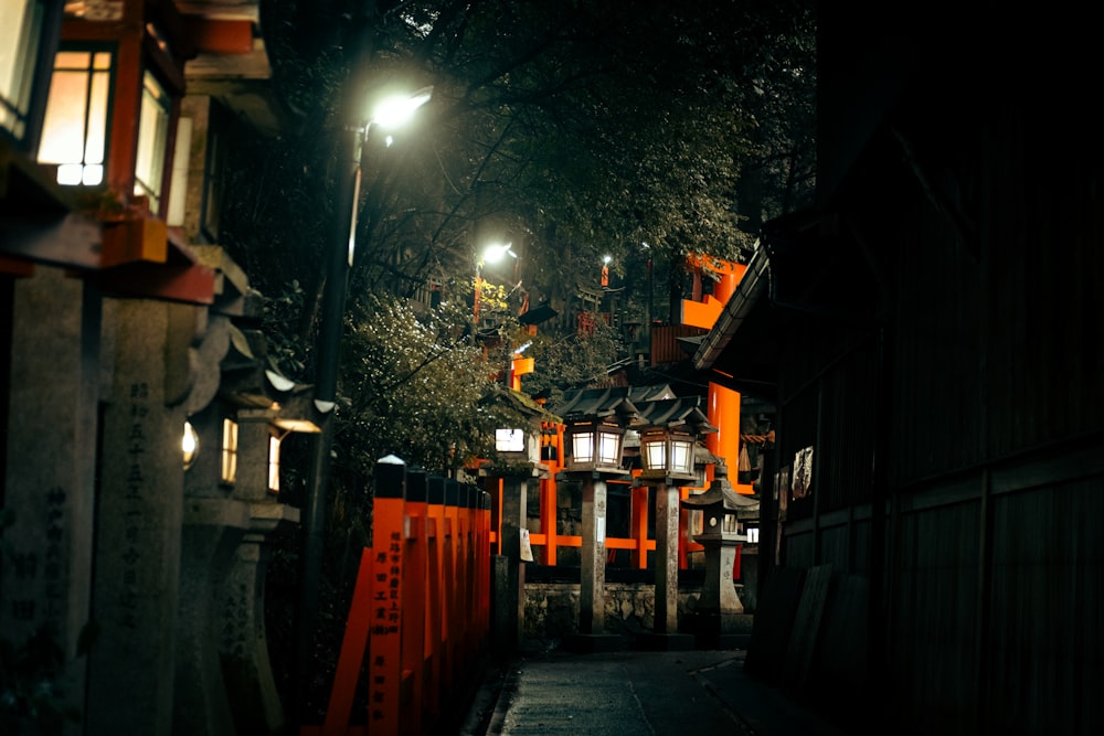 a dark street at night with lanterns lit up