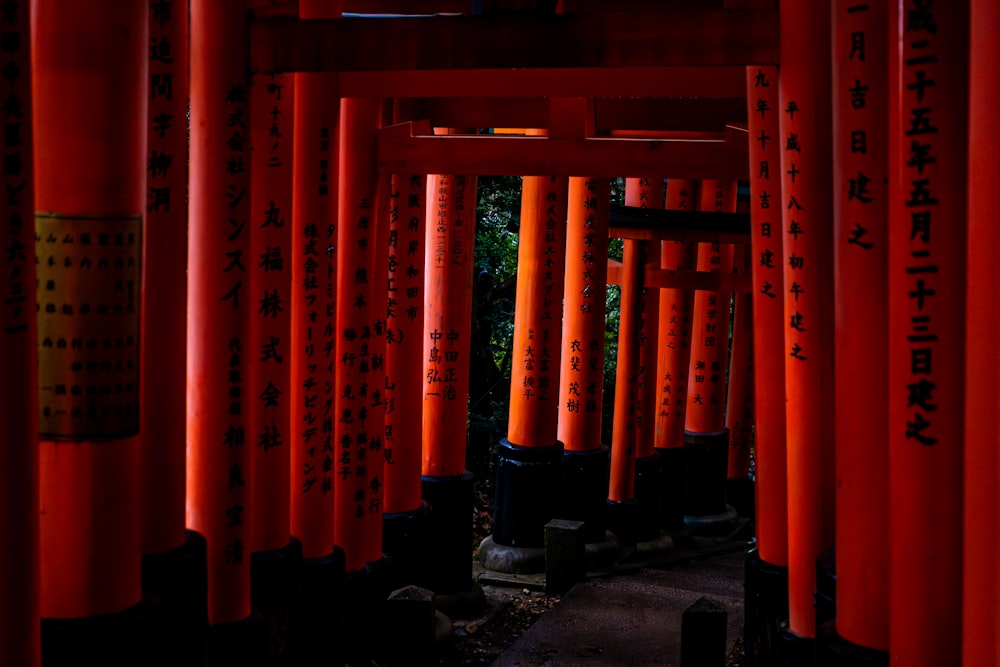 a group of red pillars with asian writing on them