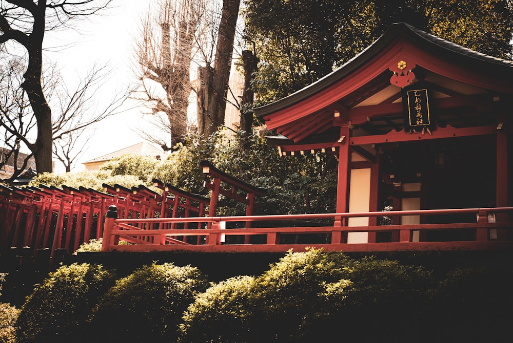 a small red building sitting next to a lush green forest