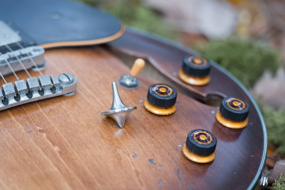 a close up of a guitar with some knobs on it