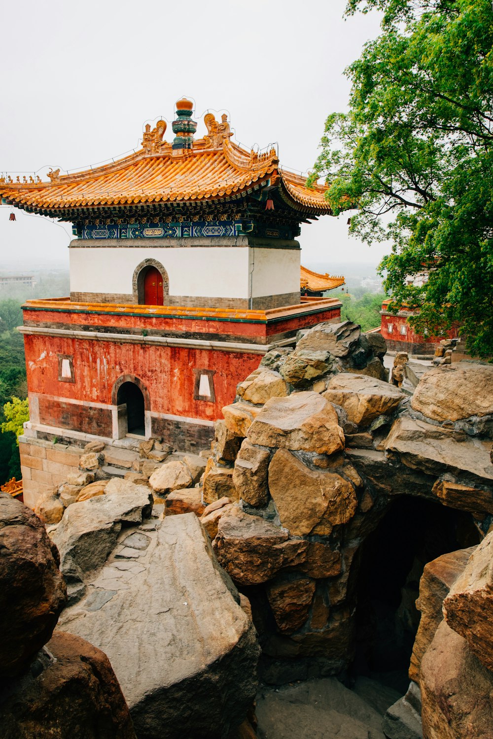 a red and white building surrounded by rocks