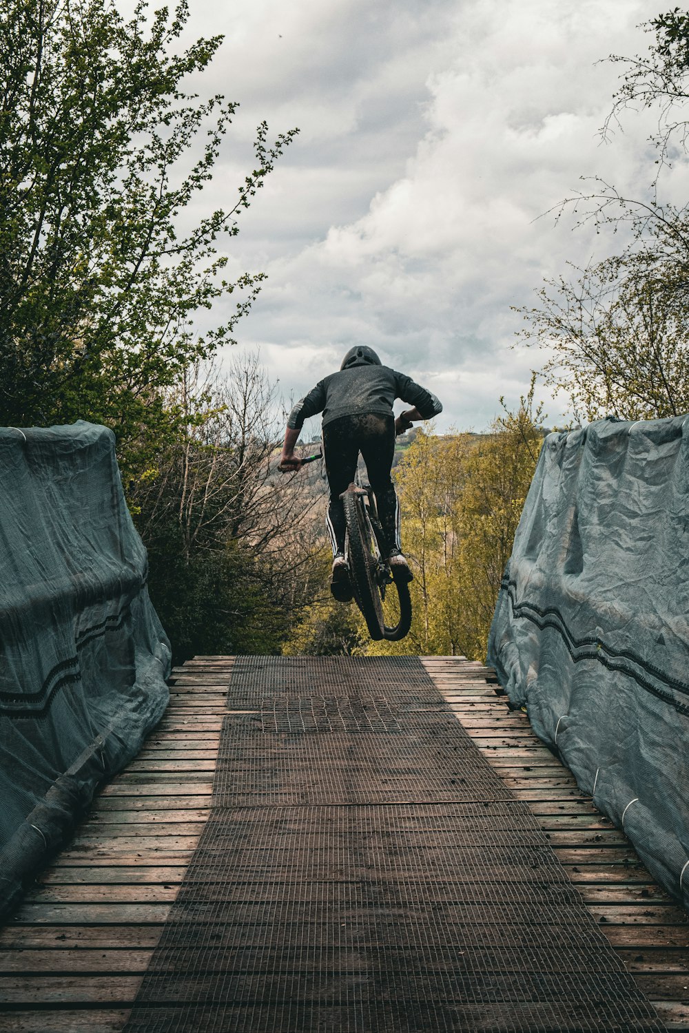 a person jumping a bike over a bridge