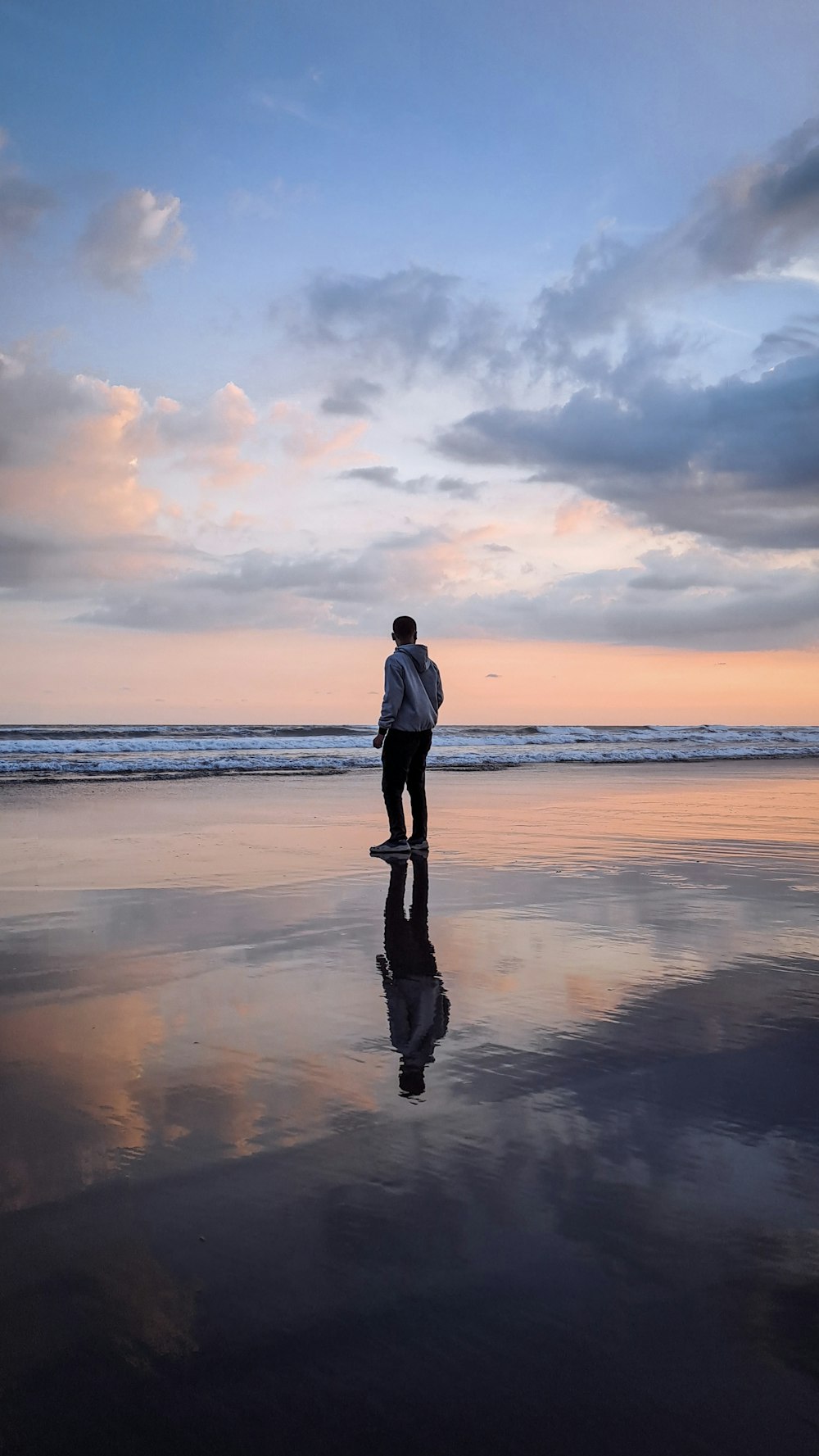 a man standing on a beach next to the ocean