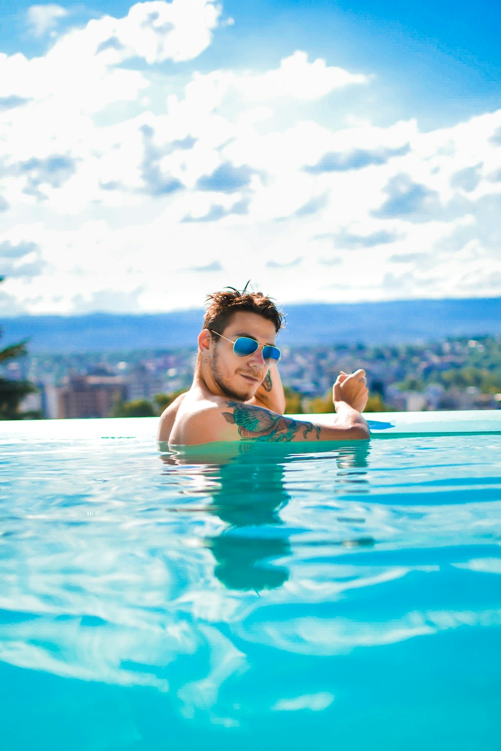 a man in a swimming pool wearing sunglasses