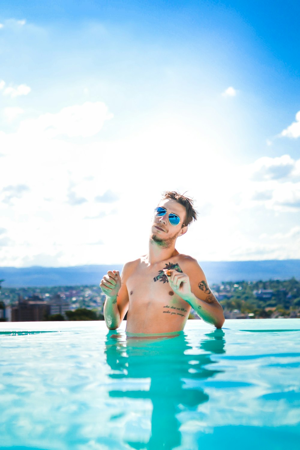 a man in a swimming pool with a tattoo on his arm