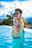 a man sitting in a pool with a cigarette in his mouth