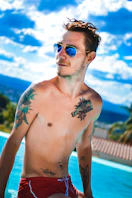 a shirtless man in a swimming pool with a frisbee