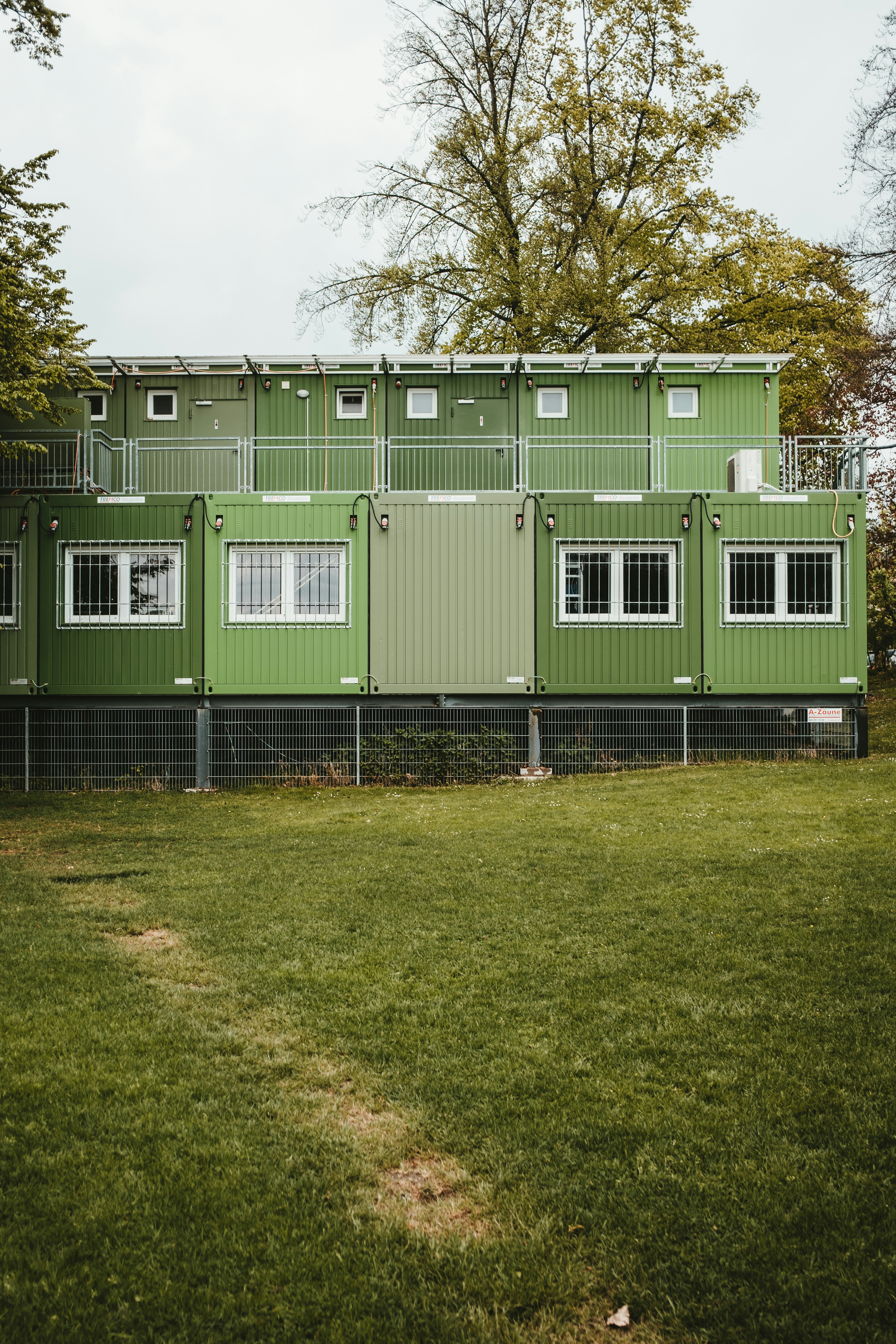 a green building with a fence around it