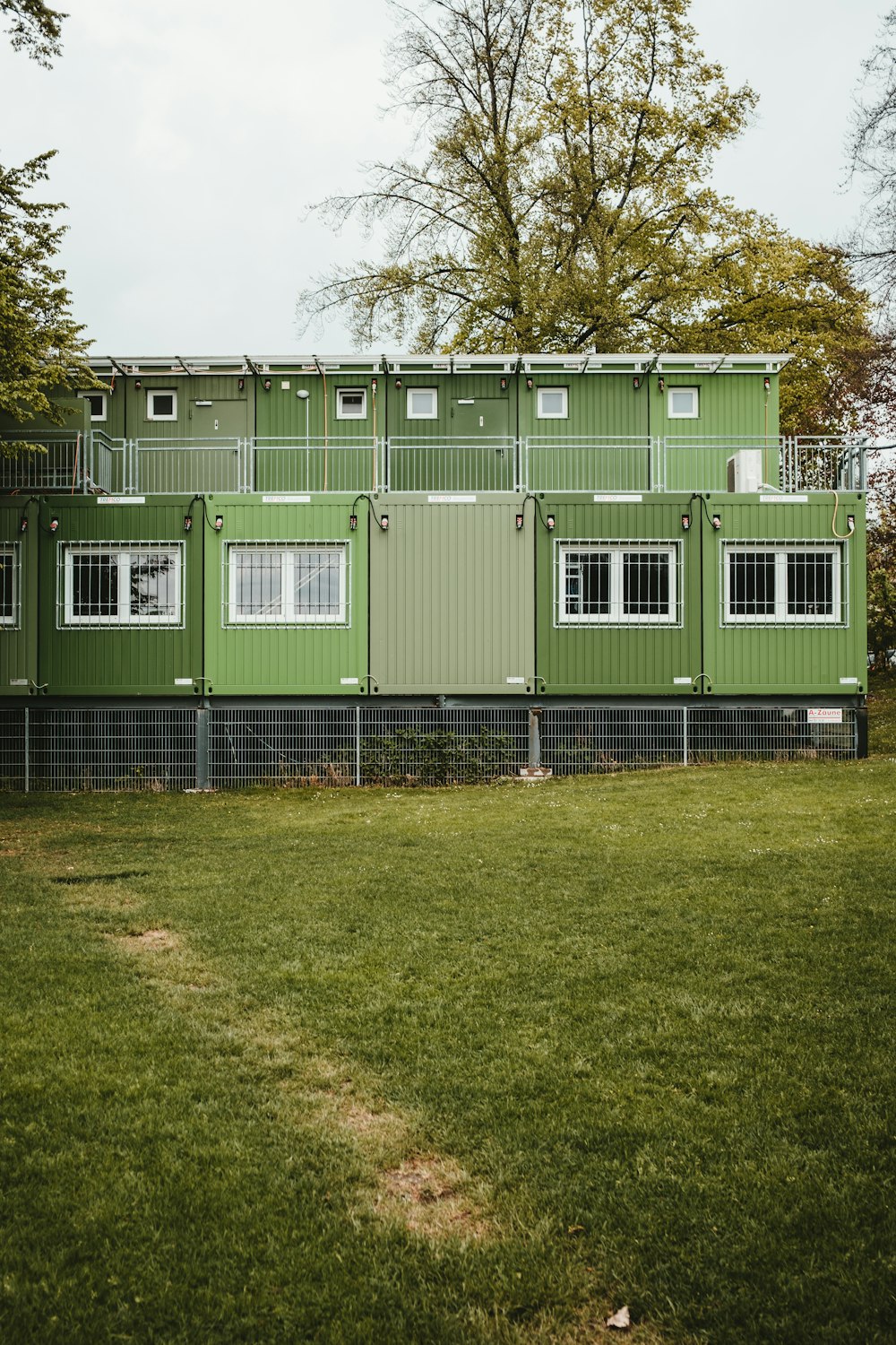 a green building with a fence around it