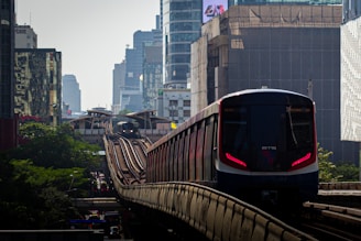 a train traveling through a city next to tall buildings