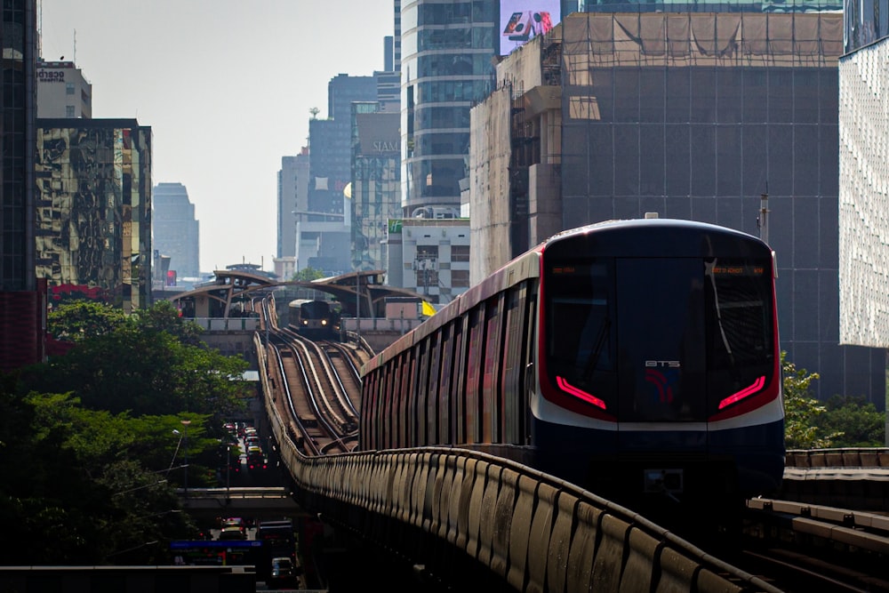 a train traveling through a city next to tall buildings