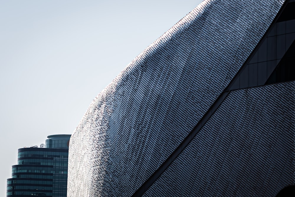 a tall building with a curved roof next to a tall building